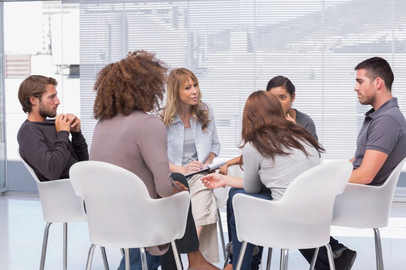 A group of people sitting around in chairs.